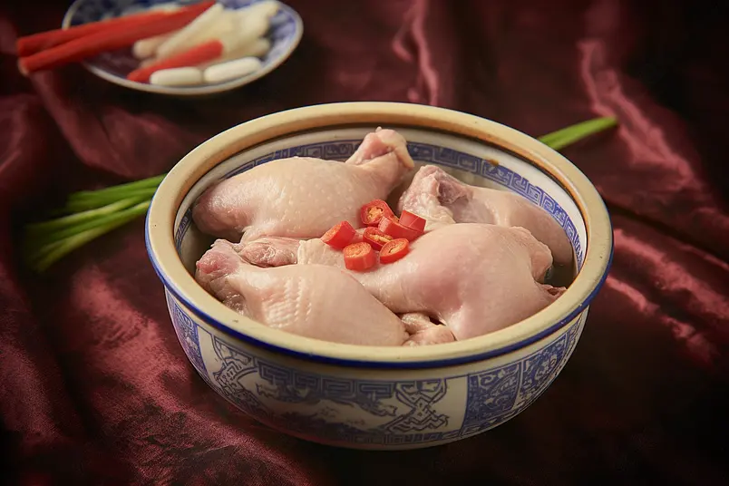 红色桌布上的瓷盆中的老鸭汤食材