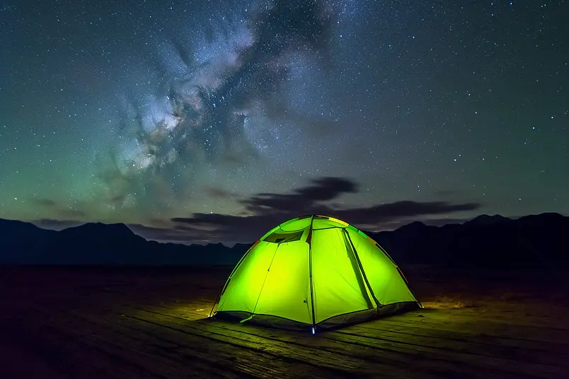 在夜晚星空下的露营帐篷绿色的光