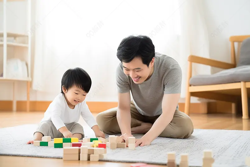 年轻爸爸陪儿子堆积木