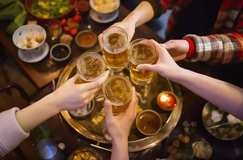 年轻人欢乐吃火锅聚餐吃饭喝啤酒