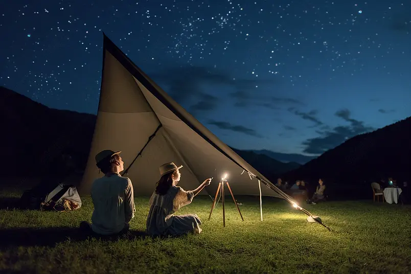 夜晚儿童在公园露营使用天文望远镜看星空摄影图