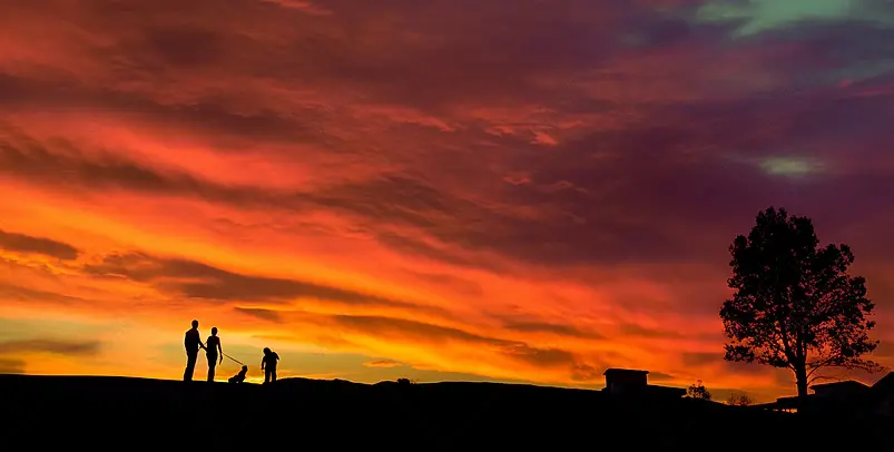 一家三口观看夕阳温馨的画面背景图